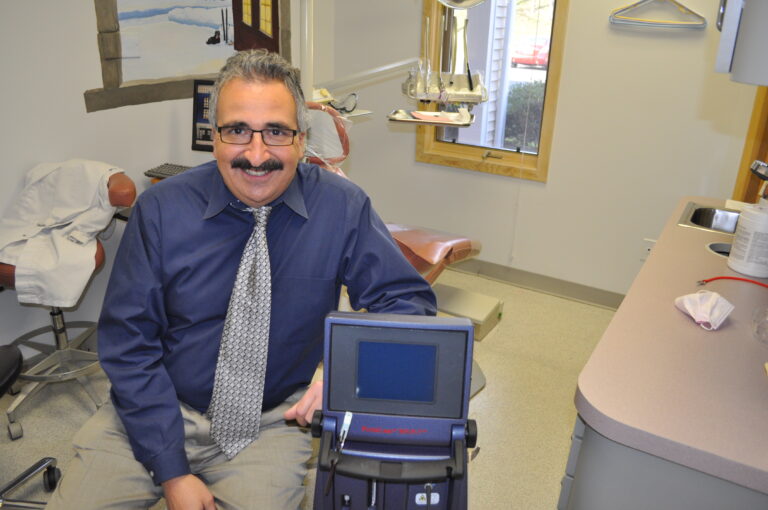 Dr. Amato professionally dressed and smiling in a seat in his dental procedure room.