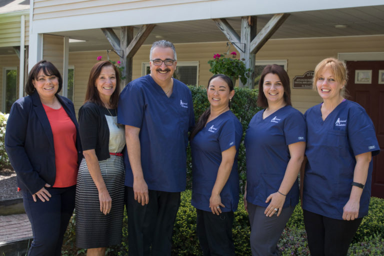 periodontist and dental team outside smiling monroe ct