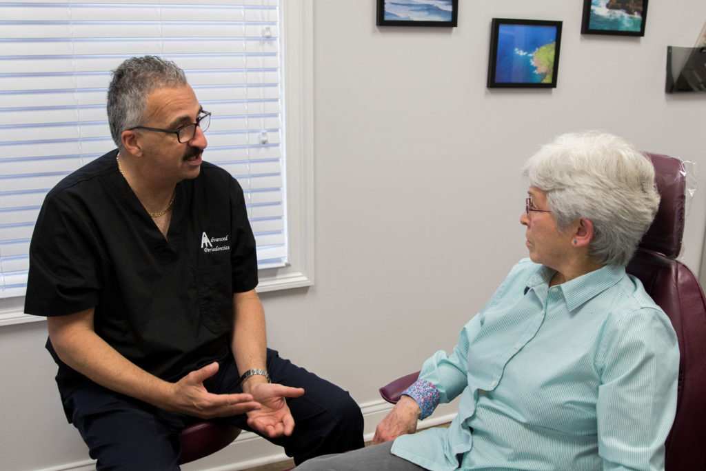 periodontist talking to dental patient about treatment